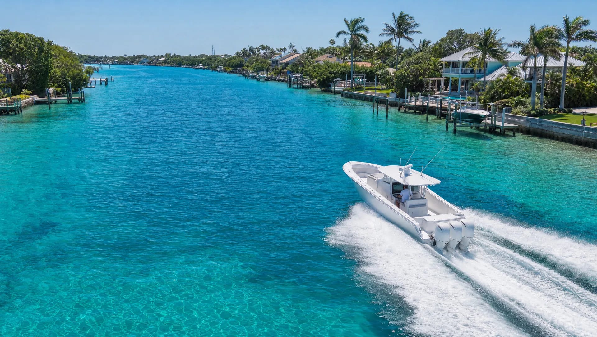 A center-console boat cruising past private docks and waterfront homes on Florida's Treasure Coast